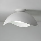 The wave silhouette of this Clérachic ceiling light stands out in white against a plain grey backdrop.