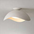 This Clérachic ceiling light in white glows warm beneath a soft beige ceiling, its shade catching the light.
