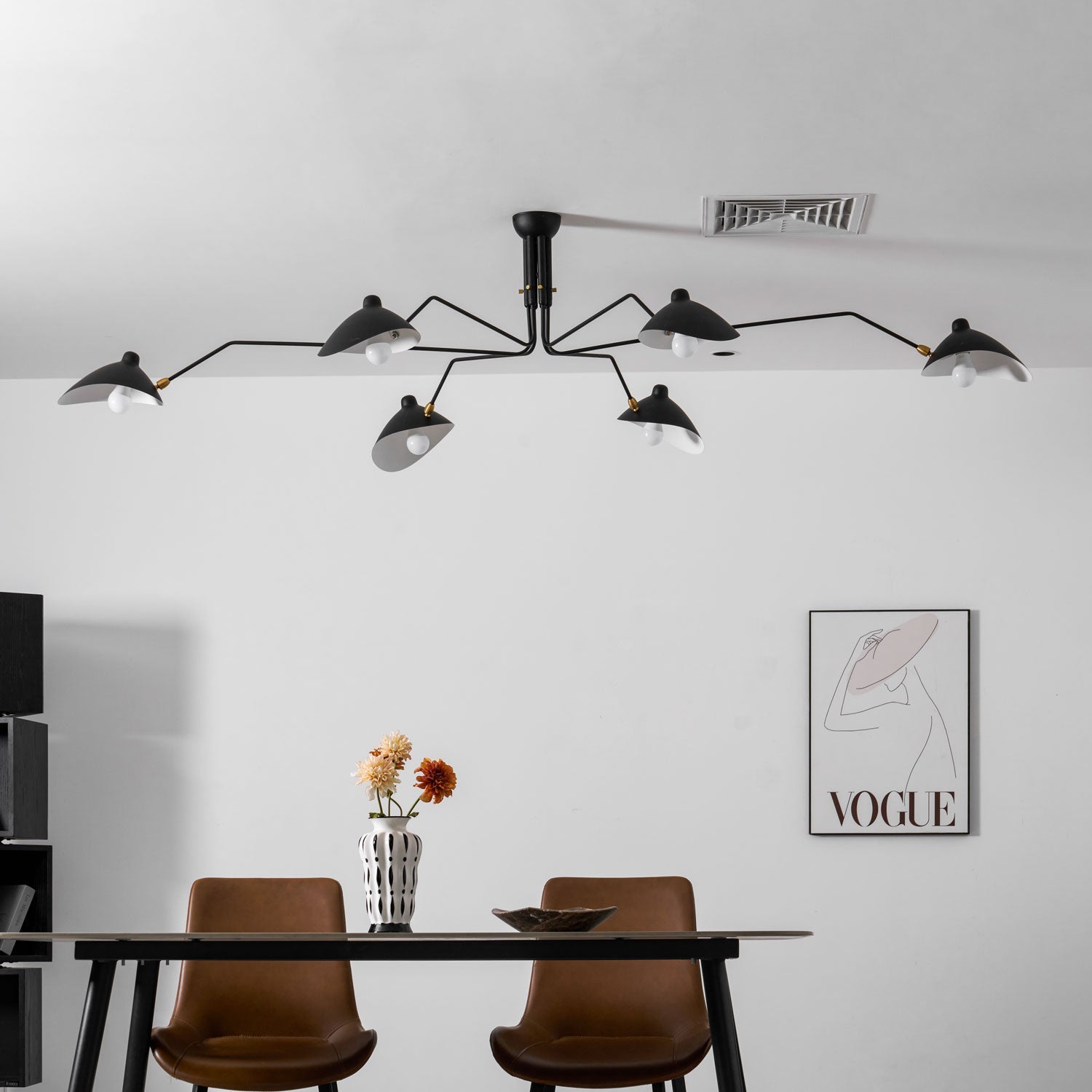 Mid-century spider ceiling light glowing over a table