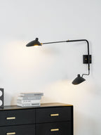 Black spider wall sconce extending light across a corner