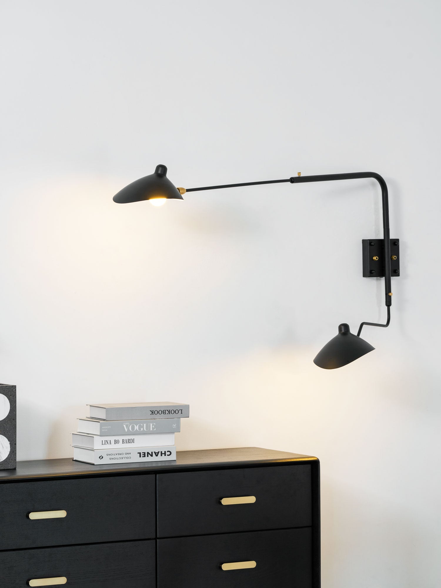 Black spider wall sconce extending light across a corner