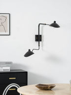 Long-arm wall sconce mounted beside artwork on a wall