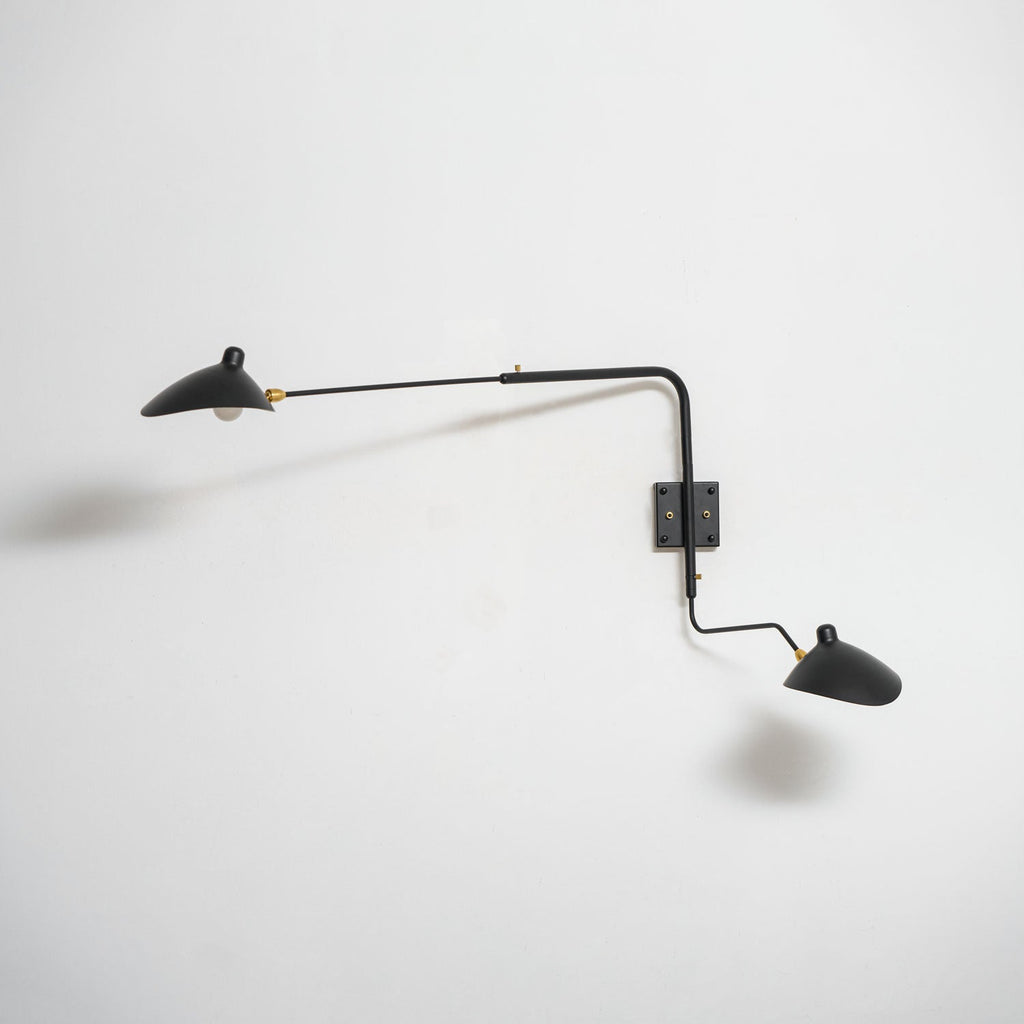 Long-arm wall sconce mounted on a wall directing light downward