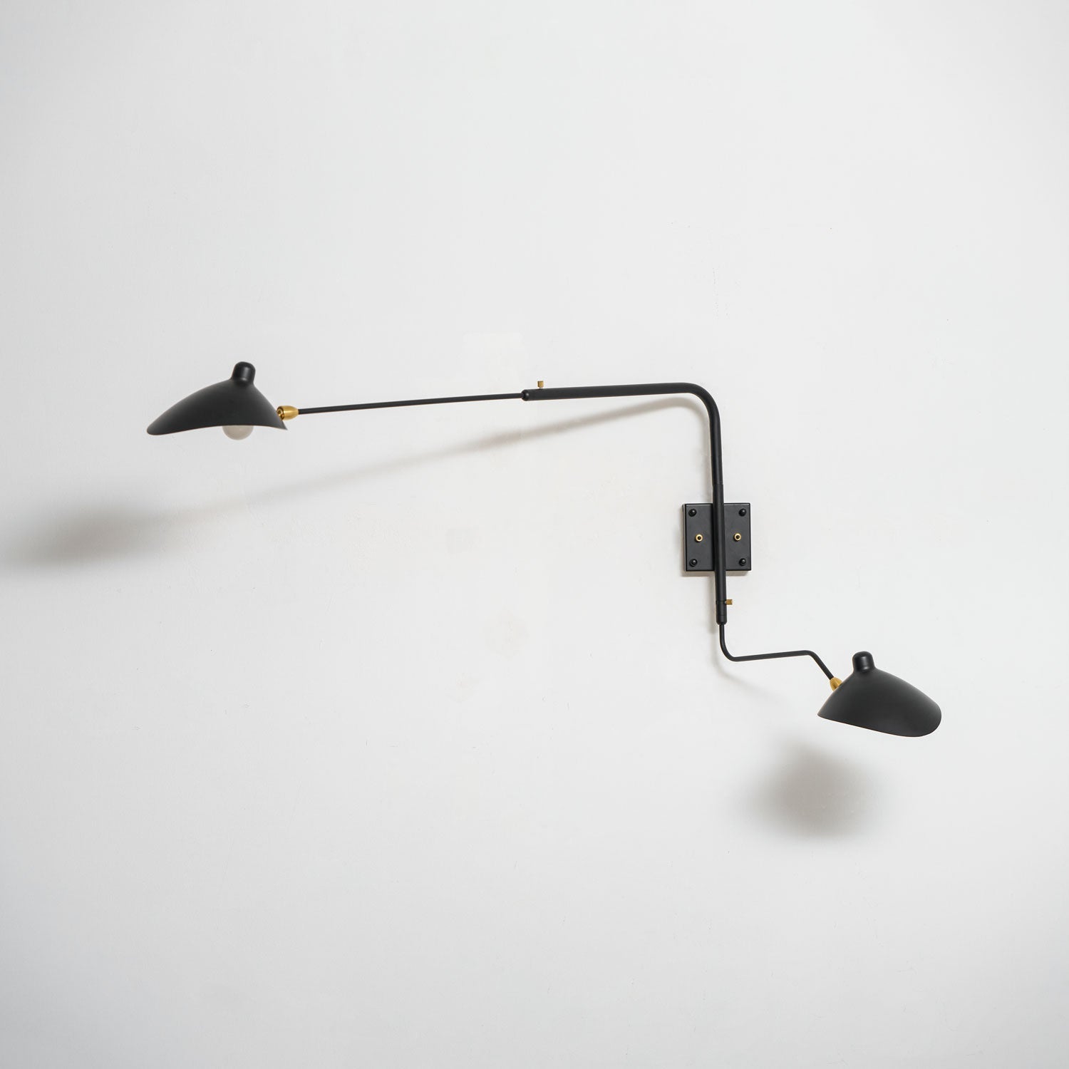 Long-arm wall sconce mounted on a wall directing light downward