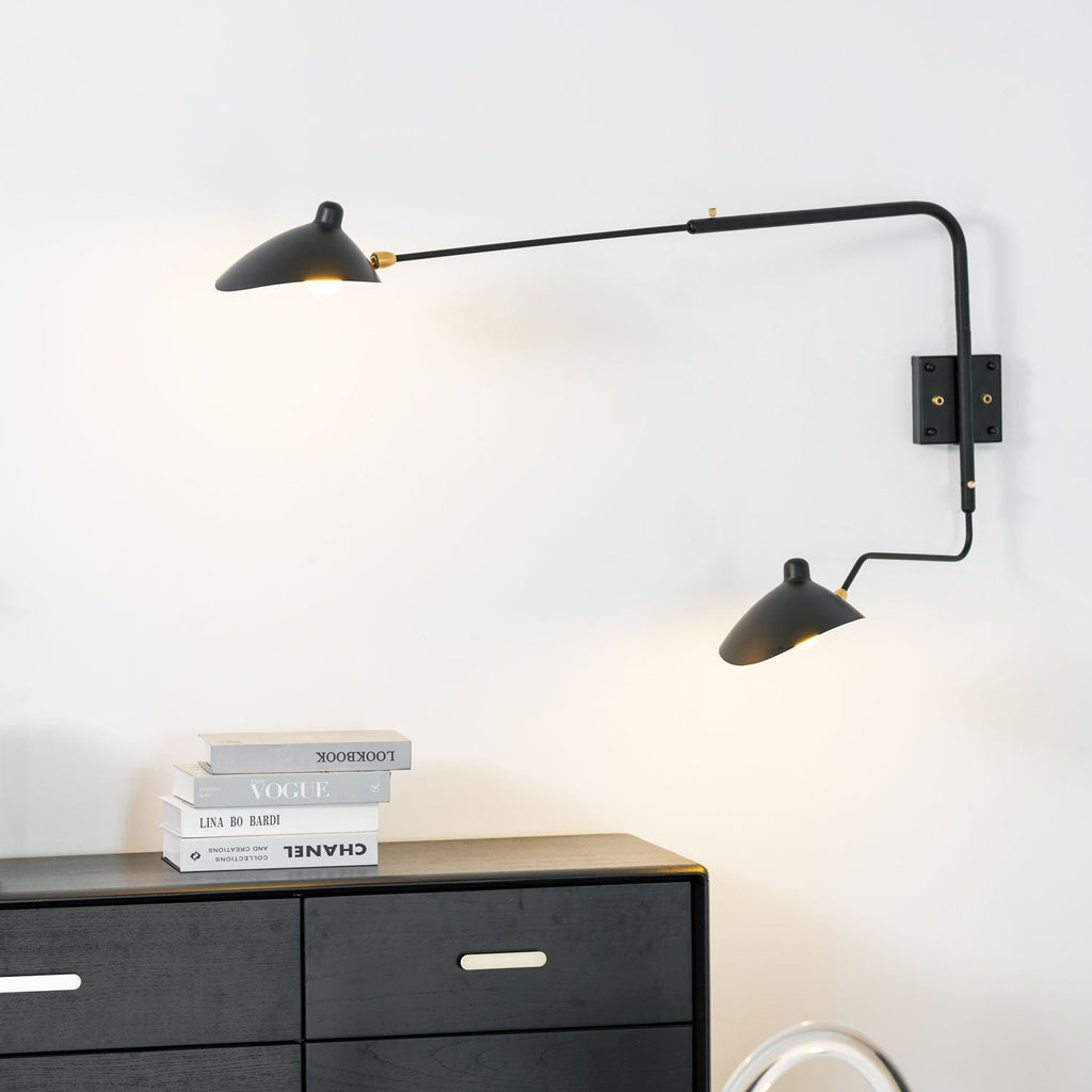 Long-arm wall sconce with cone shade angled over a sofa