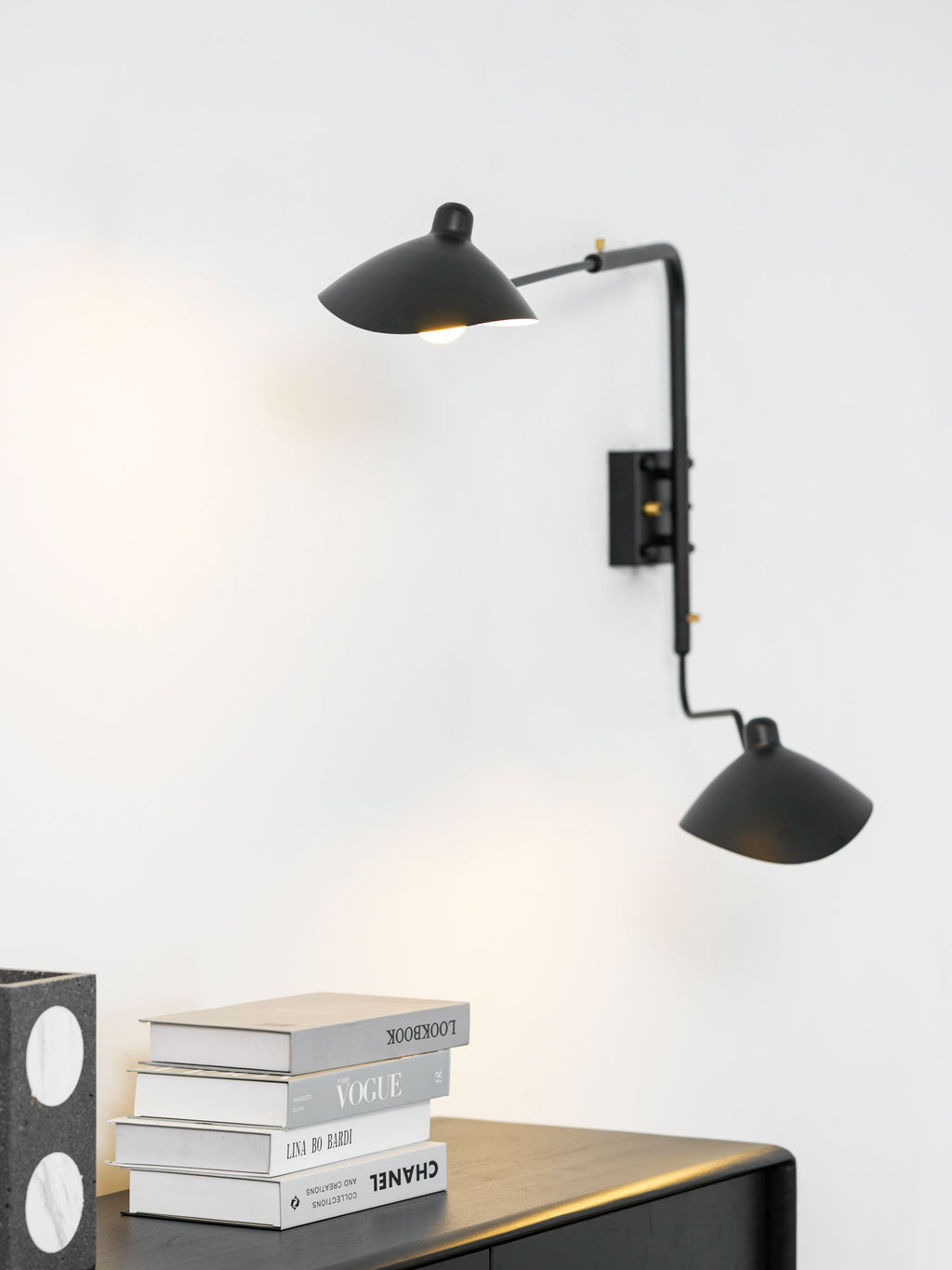 Spider wall sconce directing focused light onto a surface