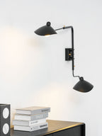 Spider wall sconce directing focused light onto a surface