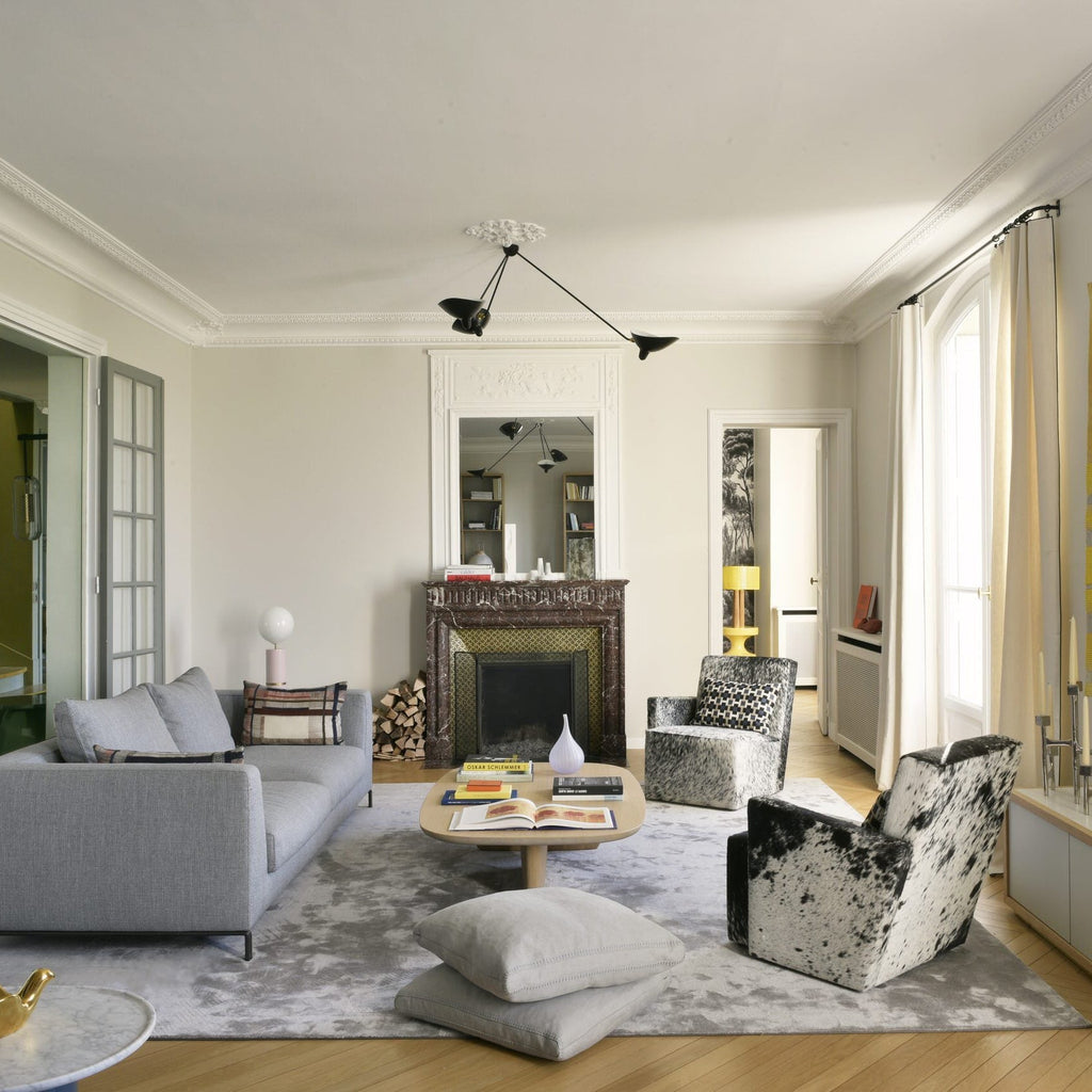 Three-arm spider ceiling light against a neutral wall