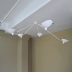 Multi-arm ceiling light with reflectors aimed in different directions