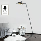 Sculptural floor lamp silhouette against a pale wall