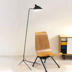 Spider floor lamp angled over a reading chair