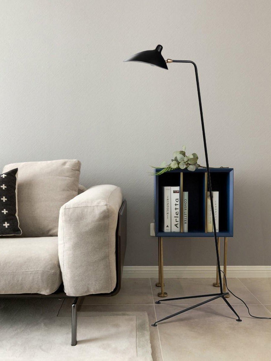 Black metal floor lamp shown beside a low sofa