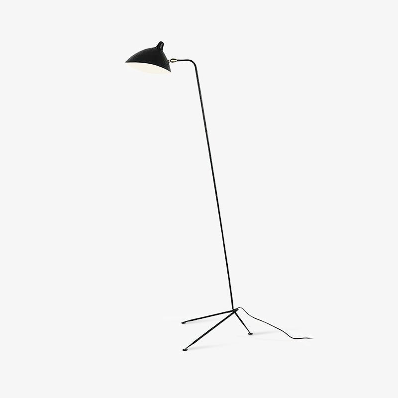 Sculptural black floor lamp beside an armchair and side table