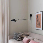 Long-arm wall sconce projecting light over a workspace