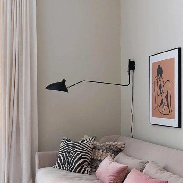 Long-arm wall sconce projecting light over a workspace