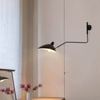 Long-arm wall sconce mounted on wall with shade angled down
