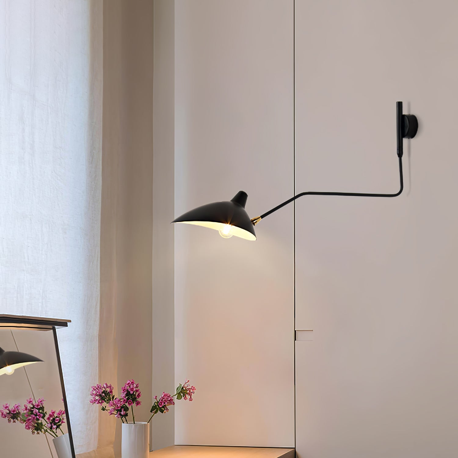 Long-arm wall sconce mounted on wall with shade angled down