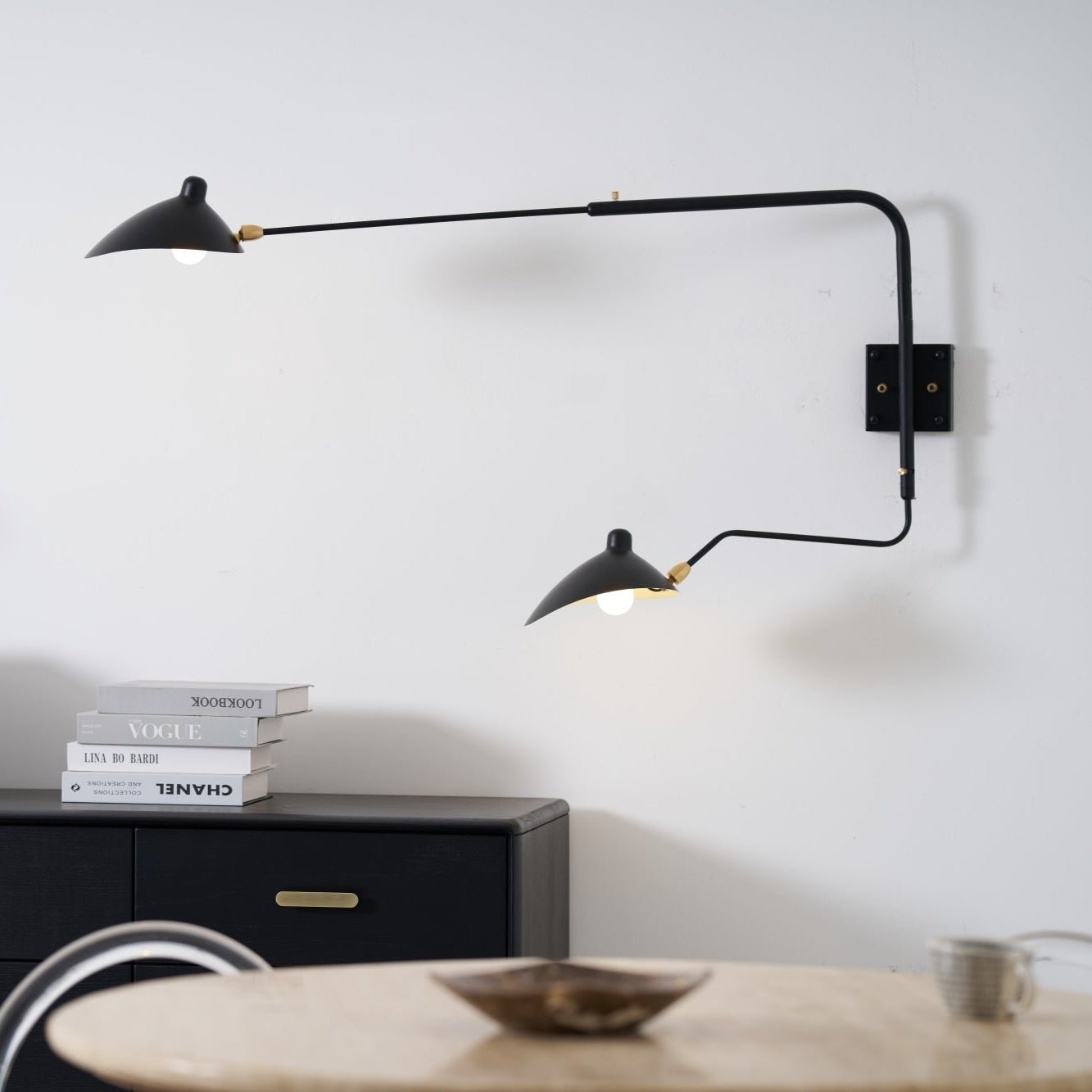Long-arm wall sconce with rotating shade in a living space