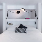Black wall sconce arm reaching out with conical shade