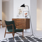 Black spider floor lamp lighting a styled living room corner