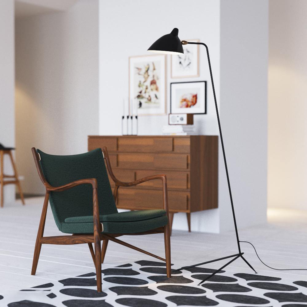 Black spider floor lamp lighting a styled living room corner