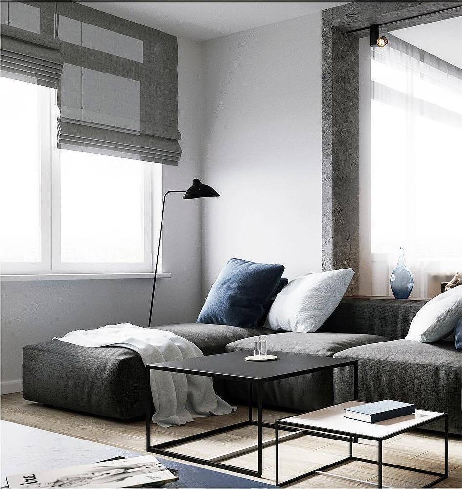 Black metal floor lamp angled over a desk workspace
