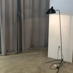 Sculptural floor lamp lighting a textured accent wall