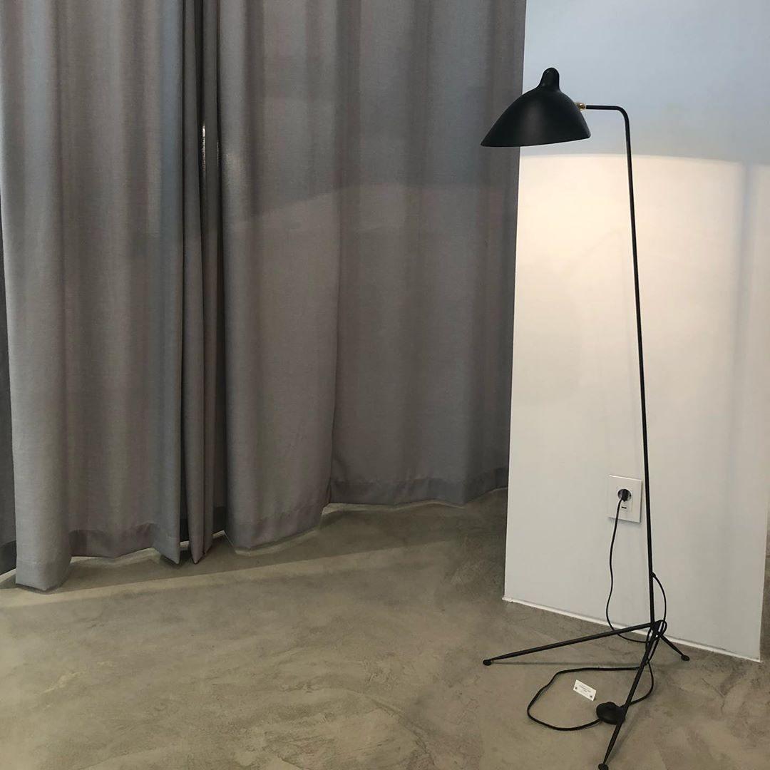 Sculptural floor lamp lighting a textured accent wall