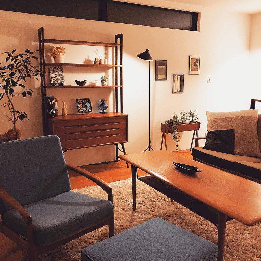 Black floor lamp with arm reaching across a seating area
