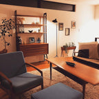 Black floor lamp with arm reaching across a seating area