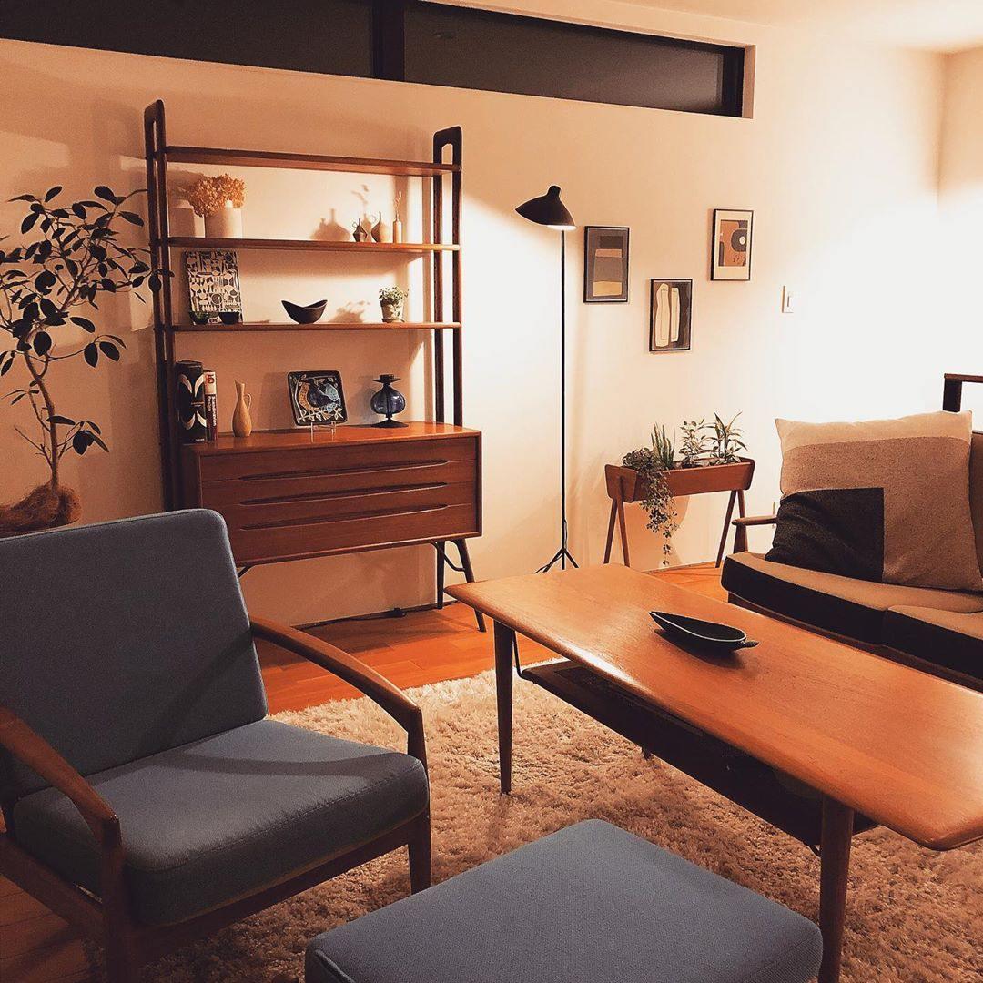 Black floor lamp with arm reaching across a seating area