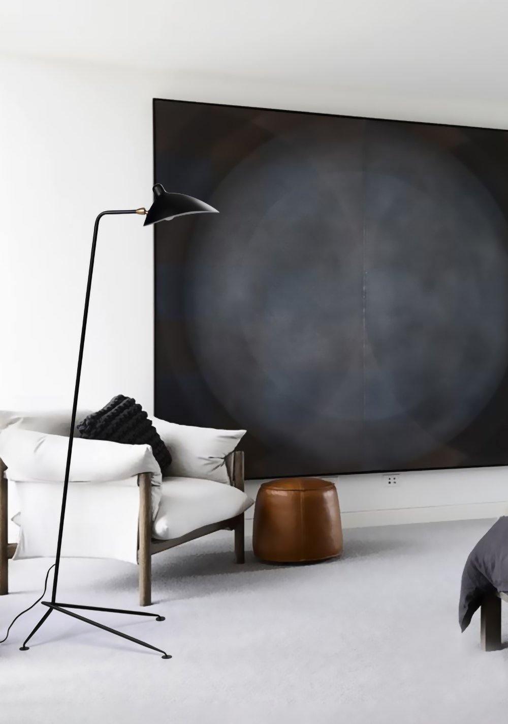 Black spider floor lamp lighting a cozy reading nook