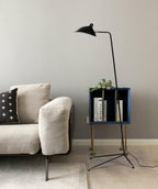 Sculptural black floor lamp against a dark feature wall