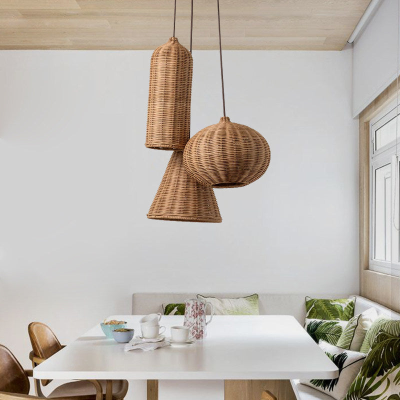Cylinder, pumpkin, and cone rattan Clérachic pendants hang above a white dining table with bench seating.