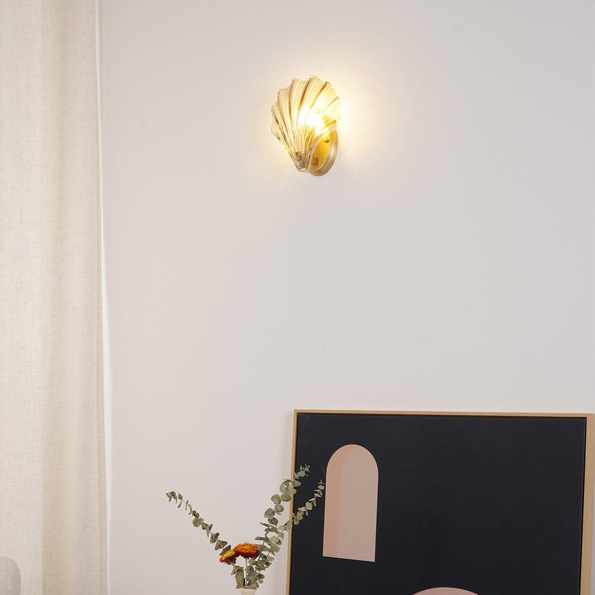 Mounted a little higher on the wall, this Clérachic wall light glows above the same side table and framed print.