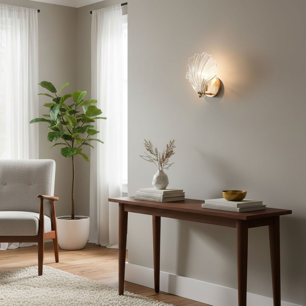 Beside a console table with a vase and a woven bowl, this Clérachic wall light glows near a potted fig plant.