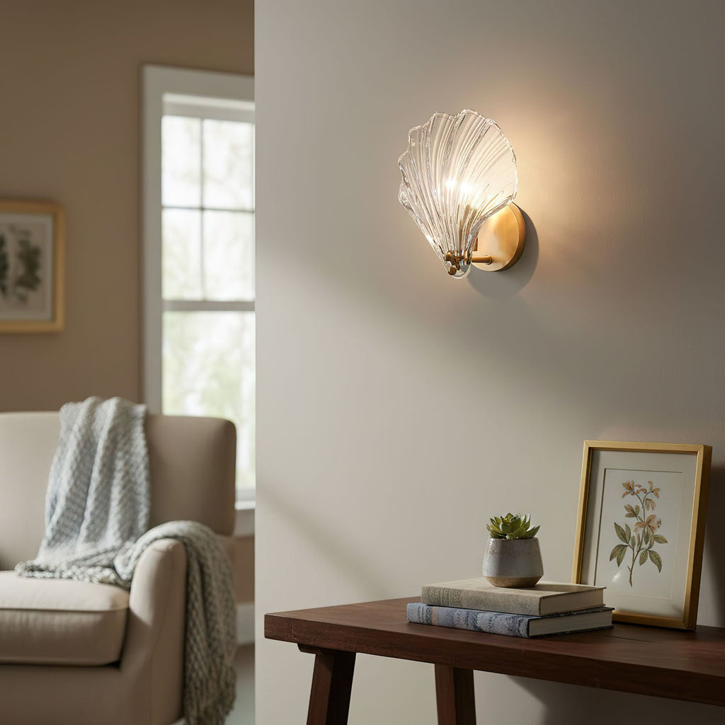 Beside a console table with books, a small plant and a framed print, this Clérachic wall light glows in a cream living room.