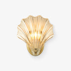 This Clérachic wall light shows its full amber glass shell and brass mounting plate against a plain white backdrop.