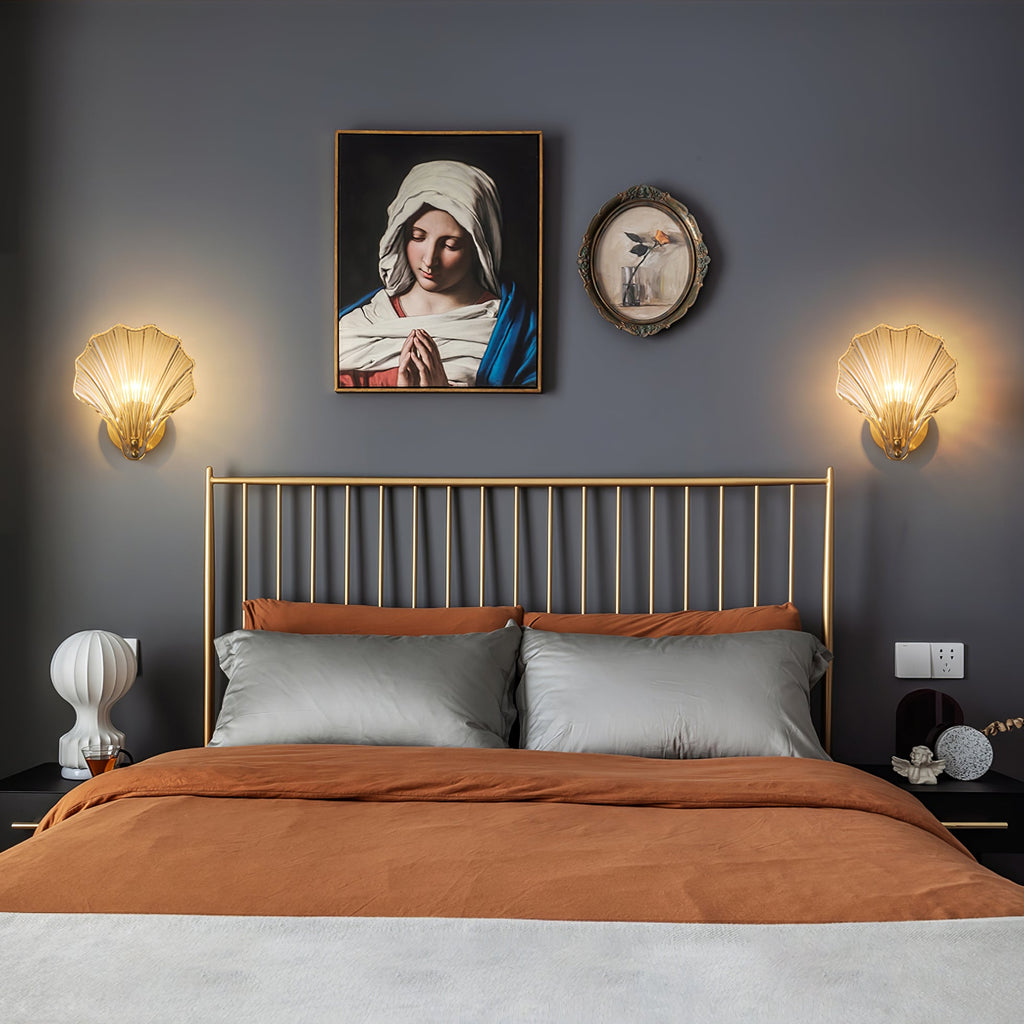 This Clérachic wall light is shown in a pair, flanking a framed portrait above a metal bed dressed in rust and grey linens.