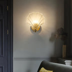 This Clérachic wall light glows on a dark grey wall beside a panelled door in a moody hallway.