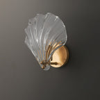 Photographed from the side against a dark backdrop, the pale glass shell of this Clérachic wall light glows brightly.