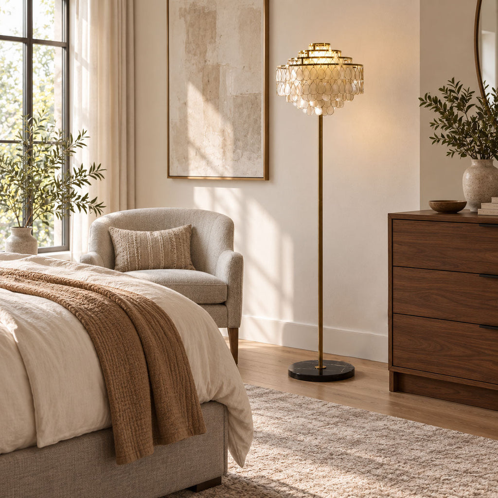 A bedroom corner holds this Clérachic floor lamp beside a walnut dresser and a soft grey armchair.