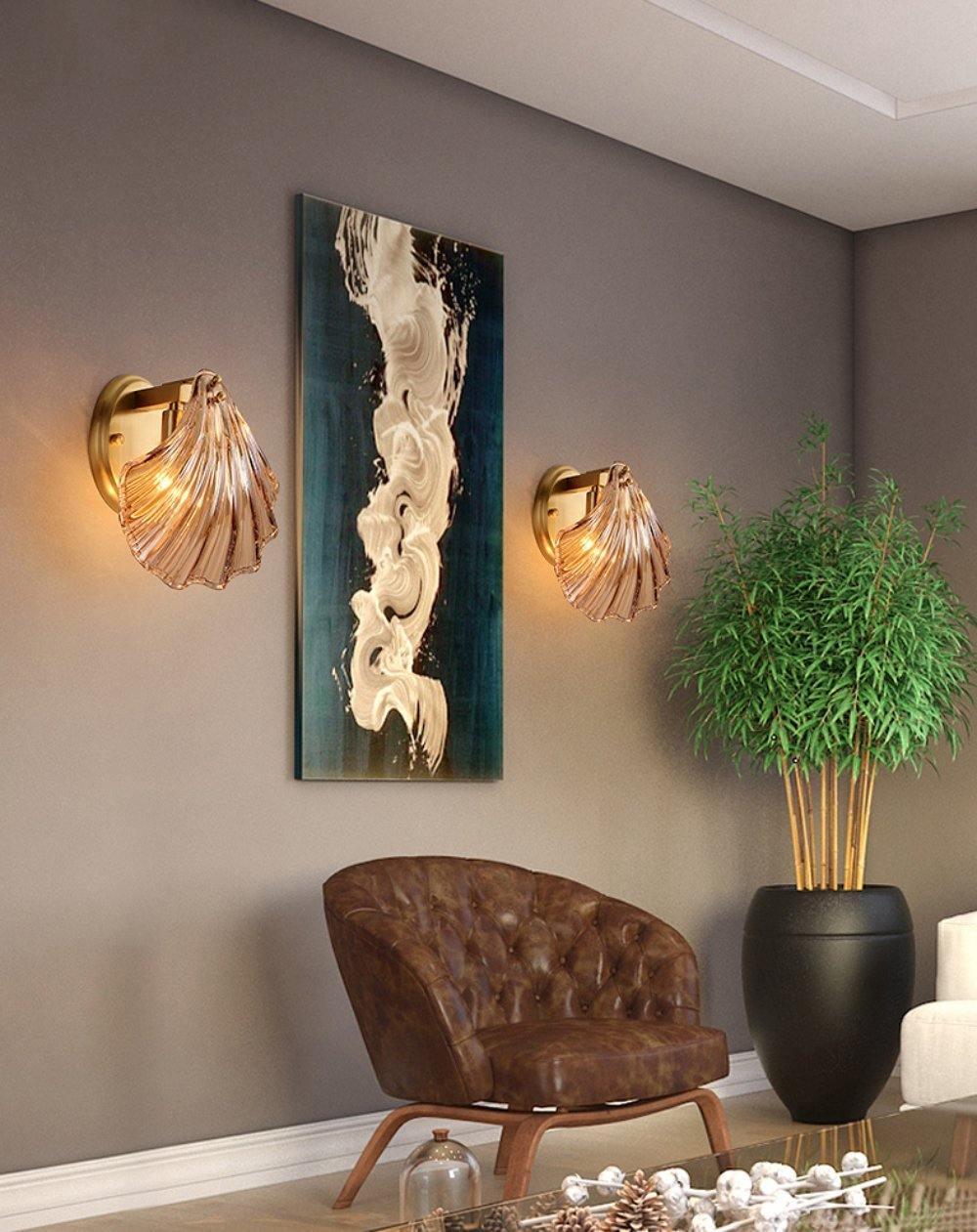 This Clérachic wall light appears in a pair, flanking an abstract print beside a leather armchair and a potted plant.