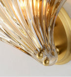 Close view of the ribbed amber glass and brass ball feet at the base of this Clérachic wall light.