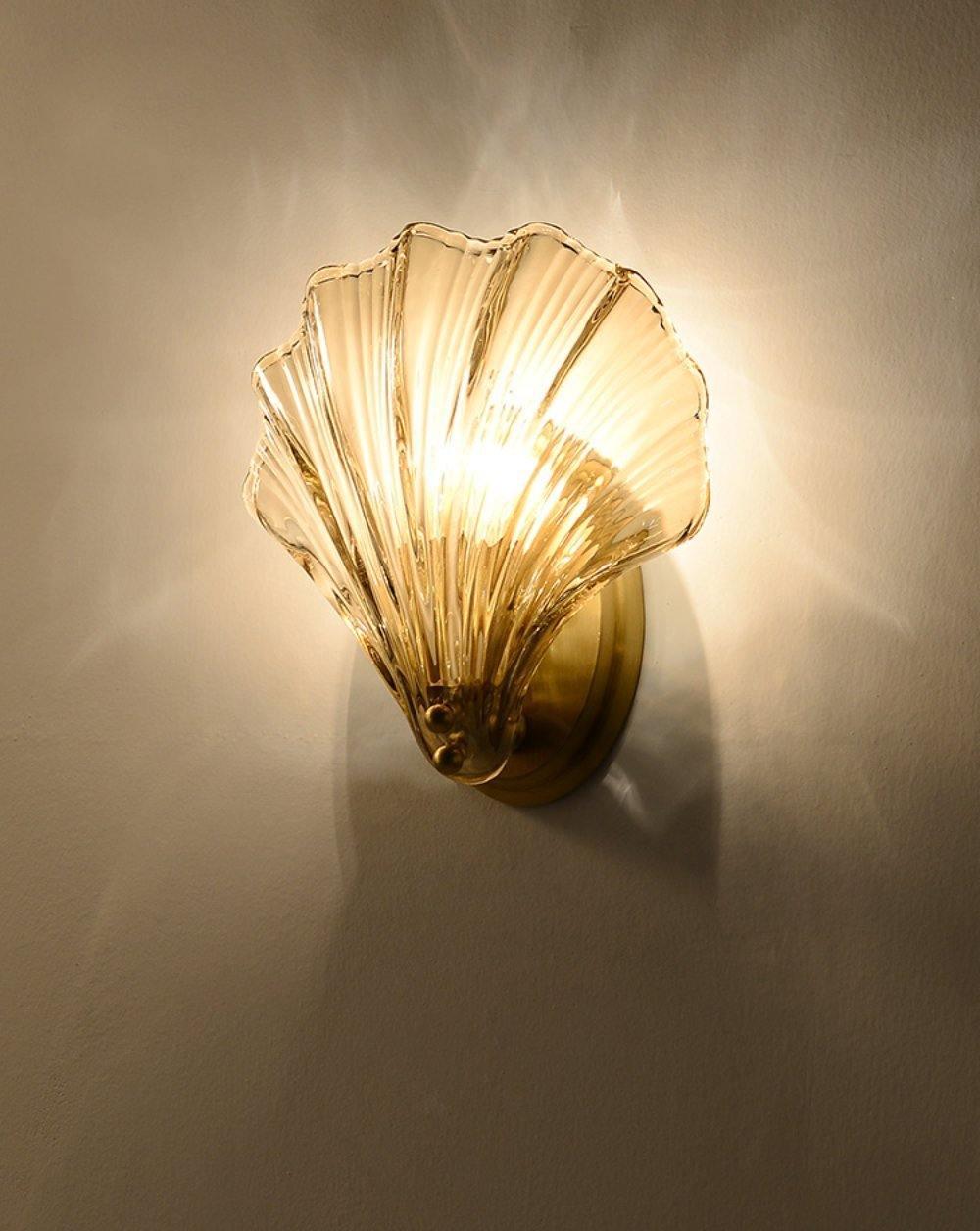 Against a warm beige backdrop, this Clérachic wall light casts a soft shadow as its amber shell glows.
