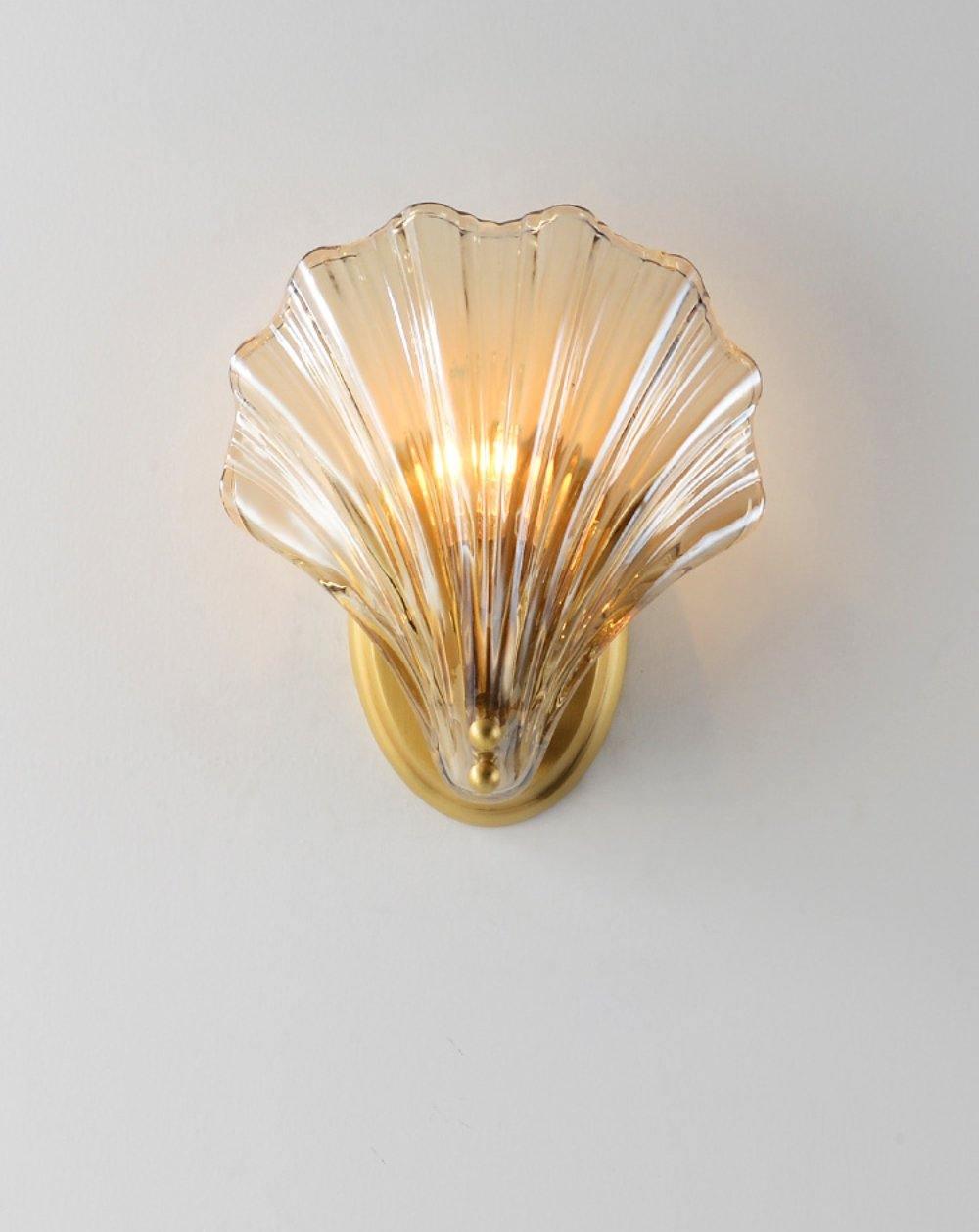 Pictured again on a plain white wall, this Clérachic wall light's amber glass shell is lit from within.