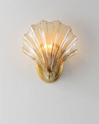 Pictured again on a plain white wall, this Clérachic wall light's amber glass shell is lit from within.