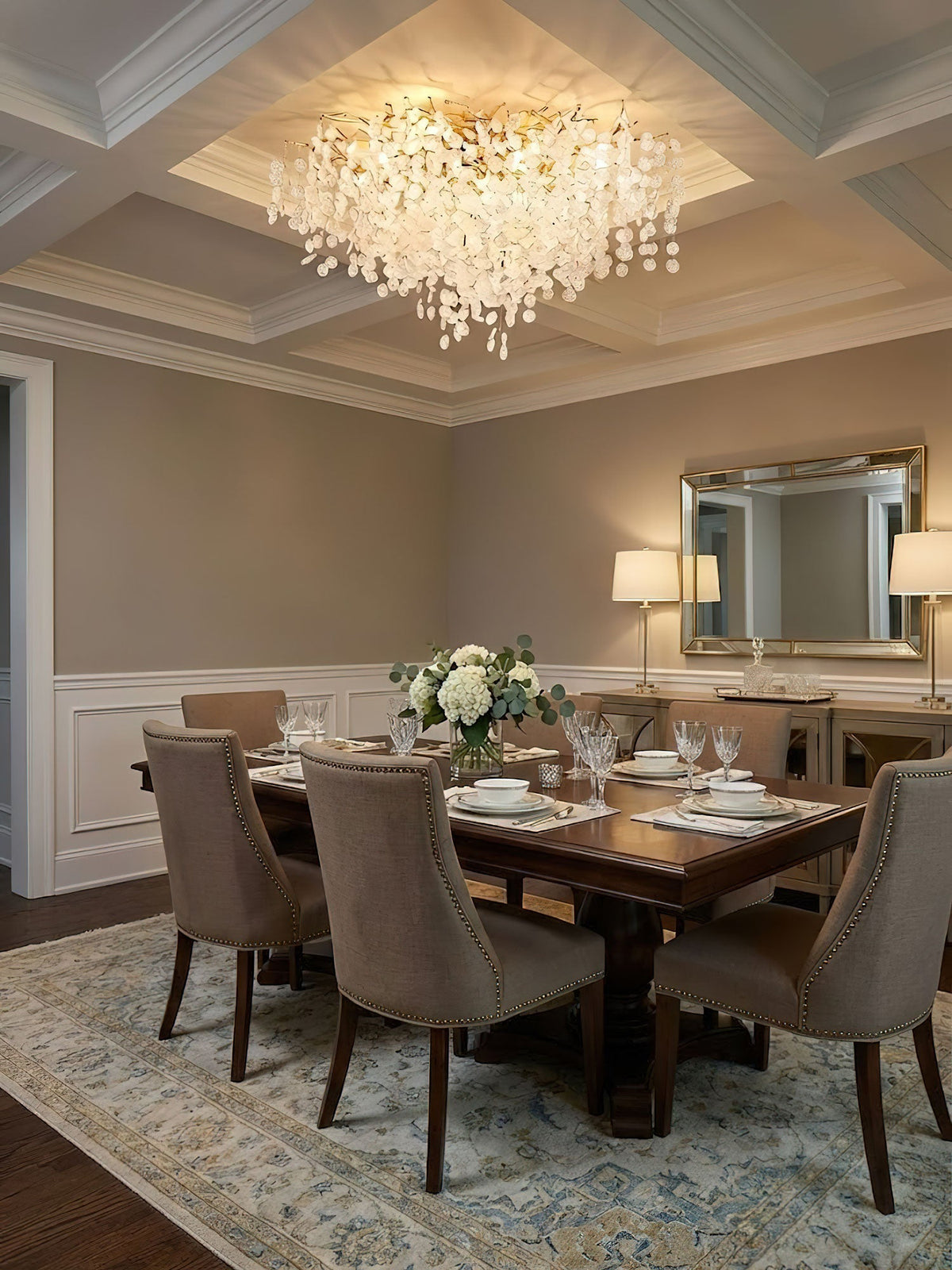 This Clérachic ceiling light lights a dining room with a coffered ceiling, above a wood table set with white place settings and a mirror.