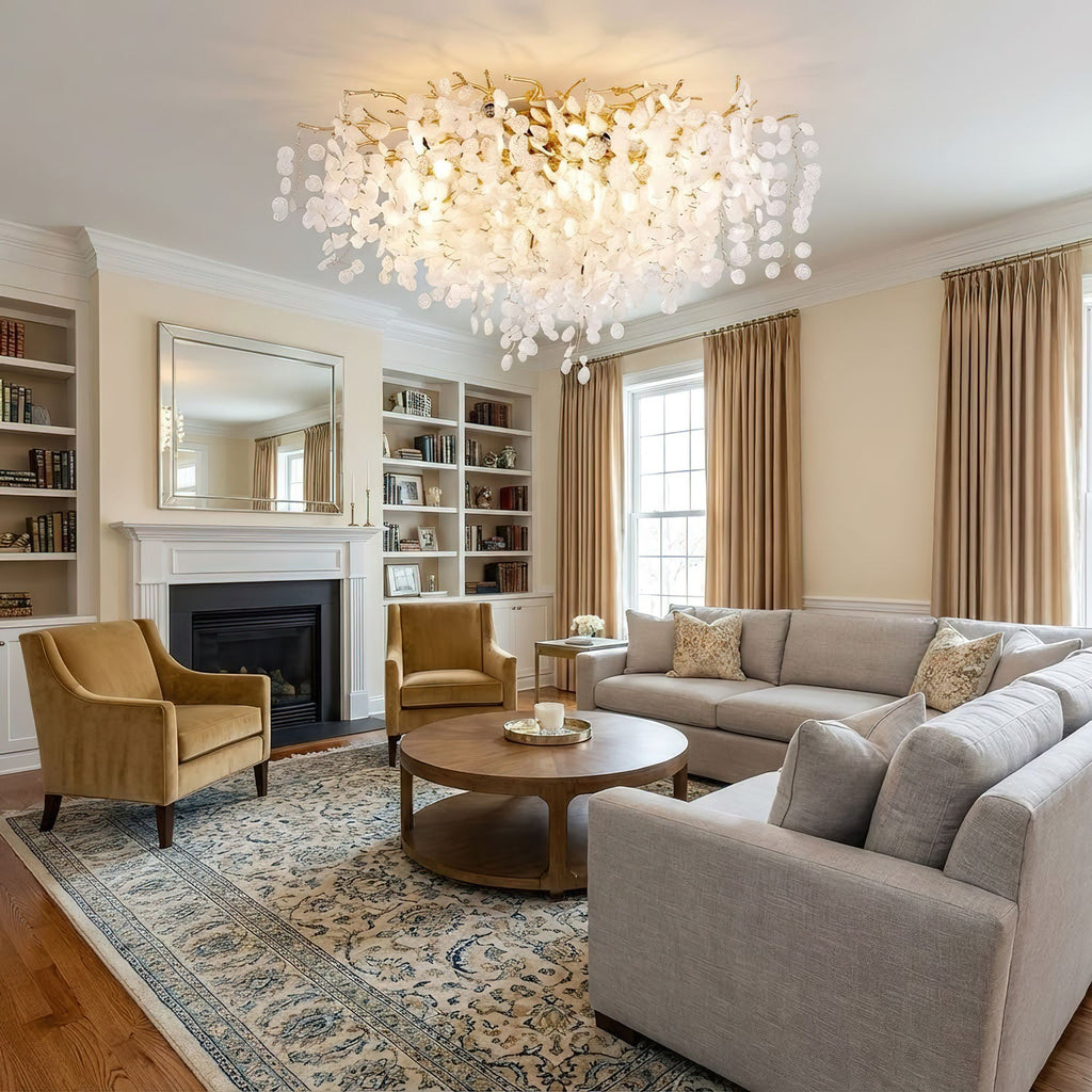 In a living room with built-in bookshelves and a fireplace, this Clérachic ceiling light glows above mustard armchairs and a round coffee table.