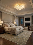 This Clérachic ceiling light glows in a bedroom with a tray ceiling, above a tufted headboard and a stone fireplace in the corner.